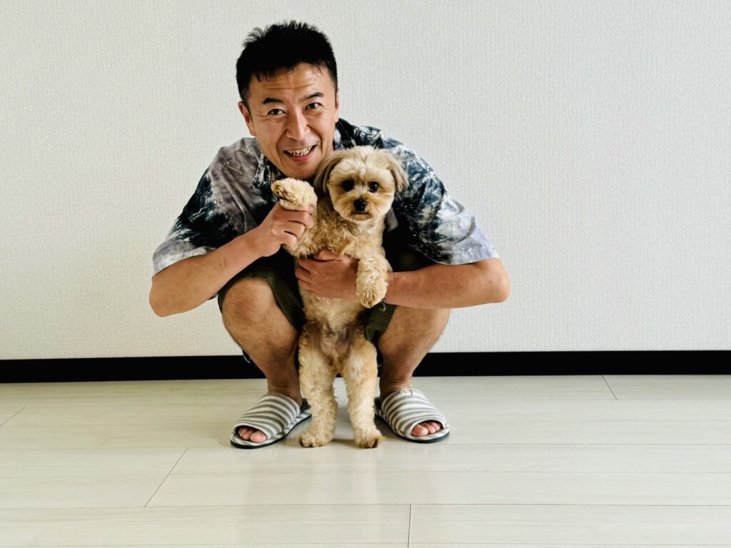 築のフローリングの上に立つ飼い主様とトイプードル