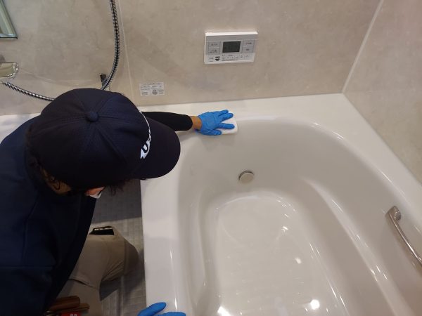 水垢やカビ、ピンク汚れなどが繁殖しやすいバスタブに防汚コーティングを施工している様子