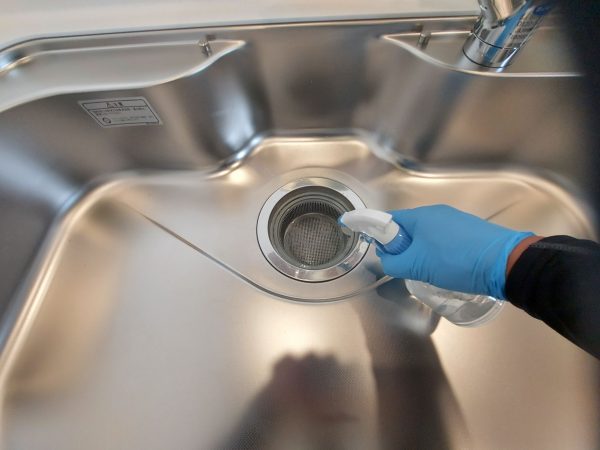 職人が水回りに防カビ防汚コーティングを施工している様子