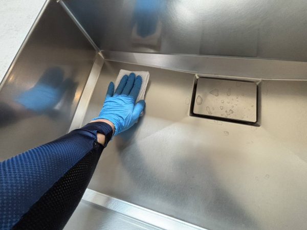 職人が水回りに防カビ防汚コーティングを施工している様子
