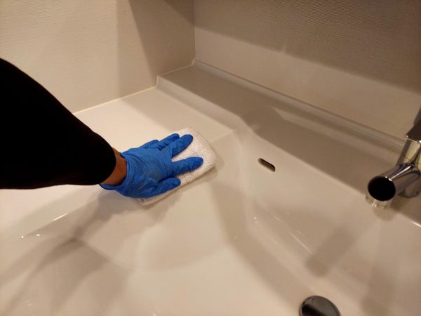 職人が水回りに防カビ防汚コーティングを施工している様子