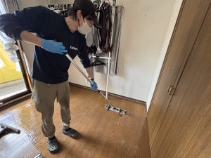 黒ずんだ床のワックスを剝離し本来の美しさを取り戻す清掃作業