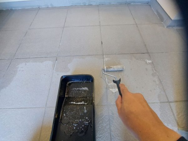職人が玄関にストーンコーティングを施工している様子