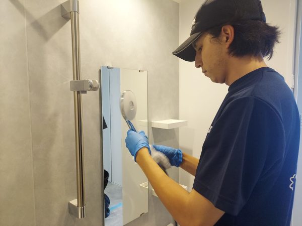 職人が水回りに防カビ防汚コーティングを施工している様子
