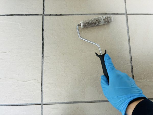 職人が玄関にストーンコーティングを施工している様子