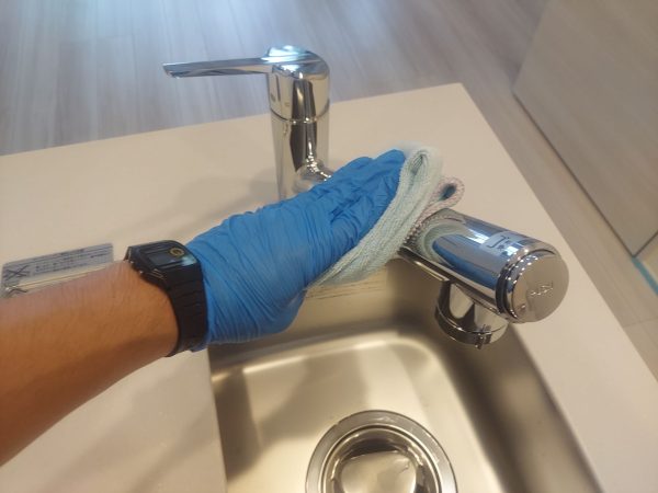 職人が水回りに防カビ防汚コーティングを施工している様子