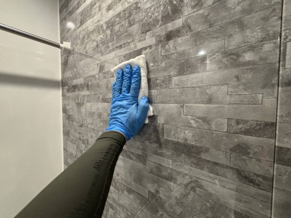 職人が水回りに防カビ防汚コーティングを施工している様子