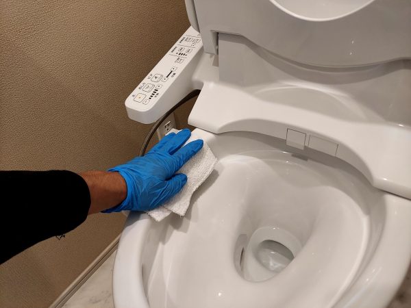 職人が水回りに防カビ防汚コーティングを施工している様子