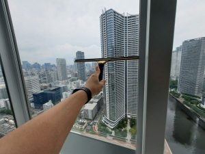 高層マンションの窓に施工された日射調整フィルムで室内温度を快適にする様子