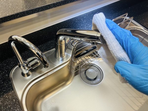 職人が水回りに防カビ防汚コーティングを施工している様子