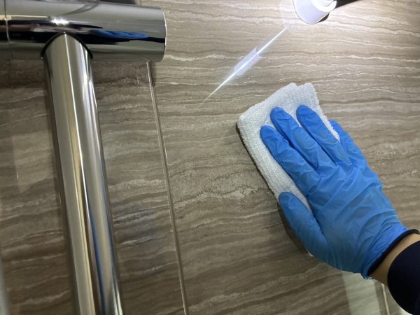 職人が水回りに防カビ防汚コーティングを施工している様子